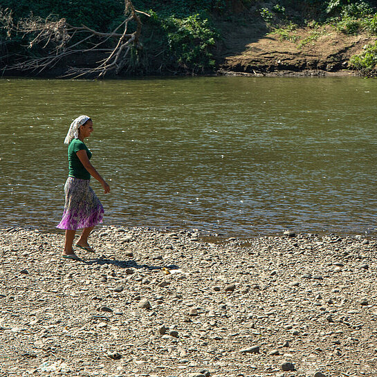 Eine Frau steht am Ufer des Río Lempa