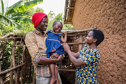 Eltern halten ihre Tochter auf dem Arm