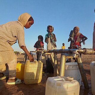 Kinder holen Wasser von der Wasserstelle in Adré