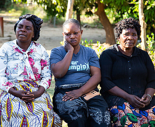 Drei Frauen sitzen draußen auf einer Bank