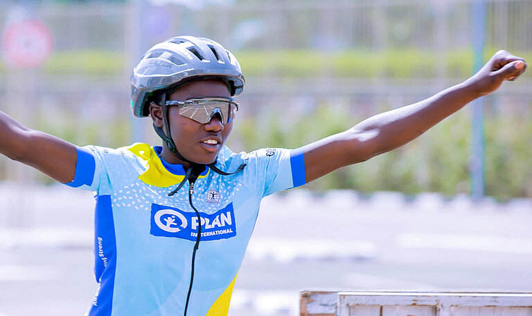 Ein Mädchen in Fahrrad-Montur freut sich über ihren Sieg als Fahrrad-Champion
