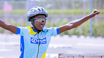 Ein Mädchen in Fahrrad-Montur freut sich über ihren Sieg als Fahrrad-Champion