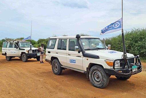 Bei riskanten Routen fahren die Plan-Teams im Konvoi und ihre Geländewagen sind mit Funk ausgerüstet Zwei Geländewagen von Plan International Südsudan