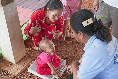 Ein Kleinkind wird gewogen