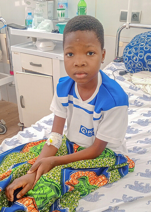 Anne sitzt auf einem Krankenhausbett