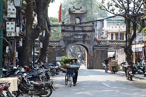 Eines der erhaltenen Stadttore in der vietnamesischen Hauptstadt Hanoi Eine Gasse mit Stadttor in Asien