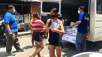 Von allen Ländern Südostasiens sind die Philippinen am schwersten von der Covid-19 Pandemie betroffen. Plan International hilft vor Ort und verteilt u.a. Hygiene-Kits an die Bevölkerung. © Plan International Plan-Mitarbeitende verteilen aus einem Lieferwagen heraus Hygiene-Kits.