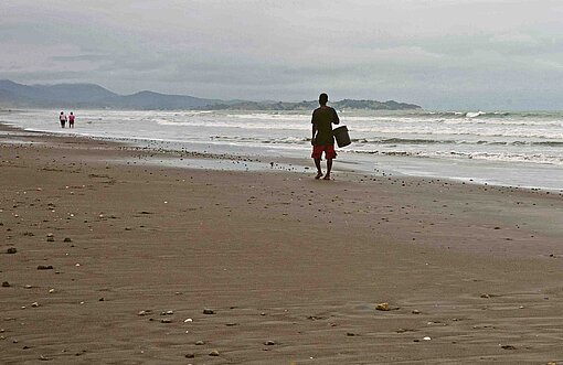 Wellen schlagen an einem weiten Sandstrand