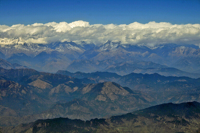 Blick über die nepalesischen Mittelgebirge zum schneebedeckten Himalaja