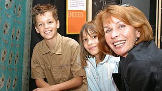 Die Schauspielerin Senta Berger mit Kindern bei Plans Erlebnisausstellung „Weil wir Mädchen sind“.