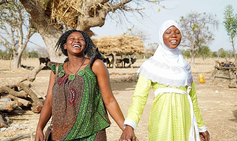 Zwei Frauen stehen lachend beisammen