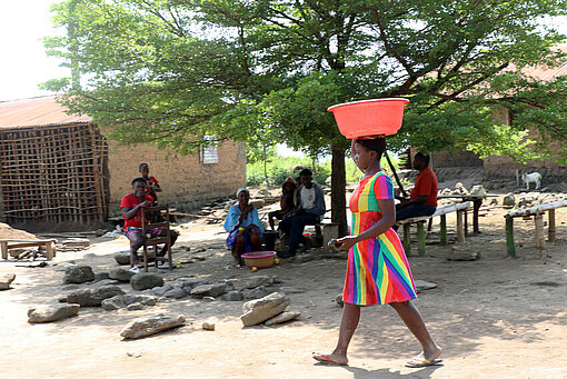 Menschen versammeln sich auf einem Dorfplatz in einem Dorf in Liberia und gehen alltäglichen Aktivitäten nach.