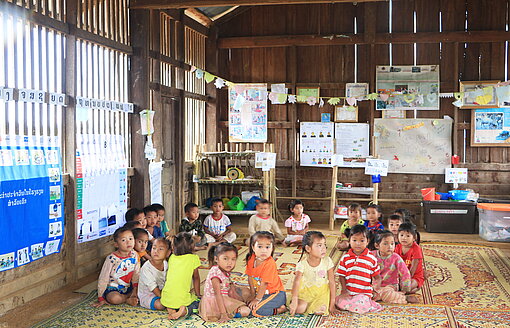 Kinder der Sommerschule sitzen im Kreis zusammen