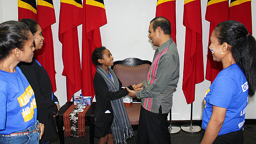 Santina schüttelt Hände mit dem Premierminister.