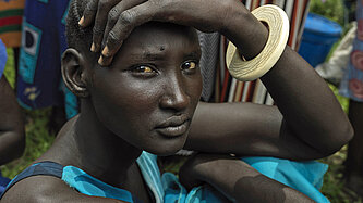 Die junge Frau Nyannyiir aus Südsudan wartet auf die Vergabe von Nahrungsmitteln