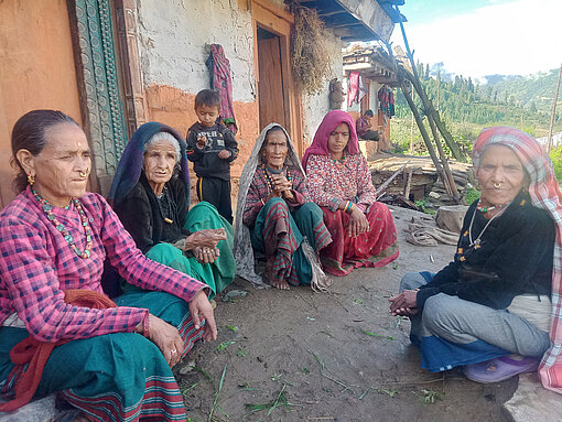 Frühverheiratung in Nepal Mehrere alte Frauen sitzen zusammen vor einem Haus, zwischen ihnen steht ein kleiner Junge