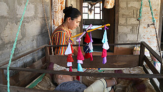 Ein buntes Mobile, das Kunta gebastelt hat, hängt über dem Kinderbett