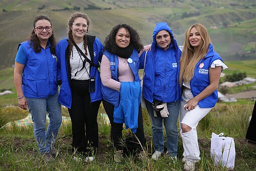 Gruppenfoto von Plan-Reisegruppe Fünf Frauen stehen auf einem Berg in Chimborazo und lachen in die Kamera.