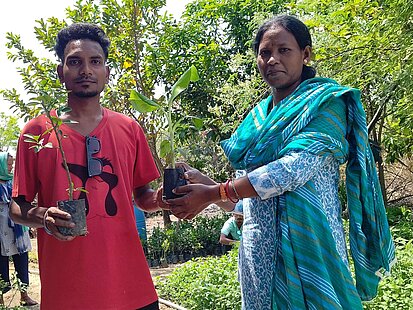 Zwei Personen halten Setzlinge in der Hand