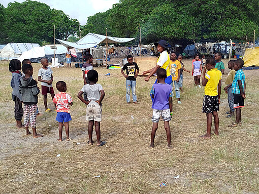 Mosambikanische Kinder stehen im Kreis und spielen etwas