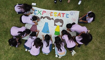 Mädchen bemalen ein Plakat zum Thema starke Frauen