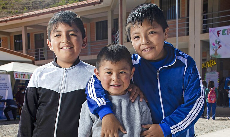 Drei Jungs in Bolivien umarmen sich