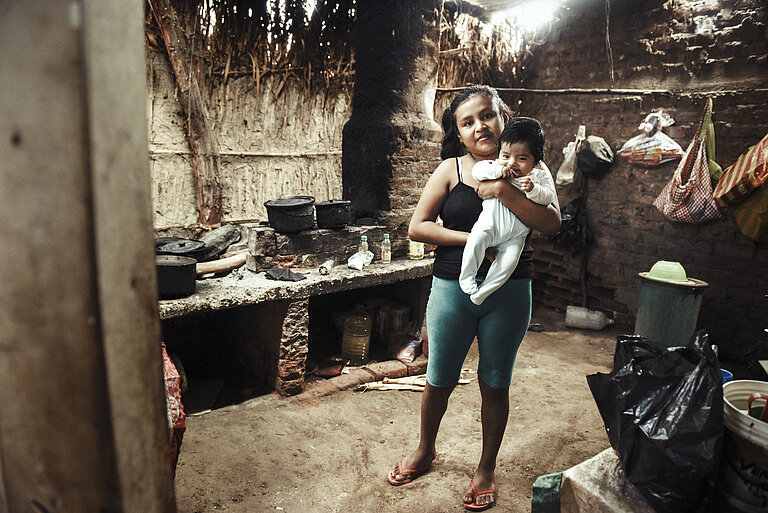 Junge Frau mit Baby auf dem Arm.