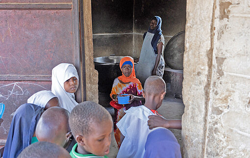 Essensausgabe an einer Schule im Bezirk Kilifi im Südosten Kenias Kinder drängen durch eine Tür in die Küche