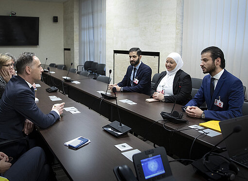 Karim sitzt gegenüber von Außenminister Heiko Maas.