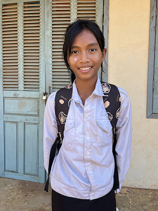 Sonita mit einem aufgesetzten Rucksack in der Grundschule 