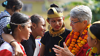 Eine Patin spricht mit ihrem Patenkind und deren Klassenkameradinnen