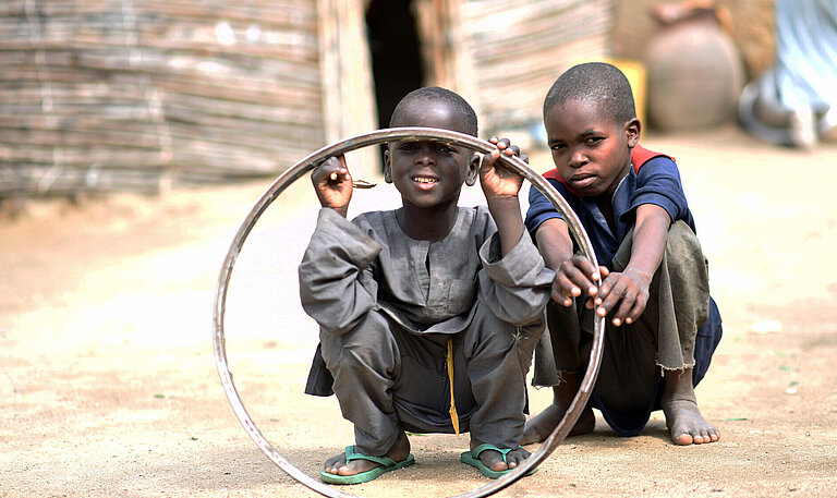 jungen-in-nigeria-spielen-mit-reifenfelge