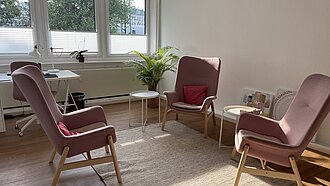 Ein gemütlicher Raum mit drei Sesseln 