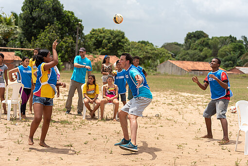 Dominik Klein spielt mit Jugendlichen im Champions of Change-Projekt in Brasilien Handball Jugendliche werfen sich über Handballer Dominik Klein hinweg einen Ball zu