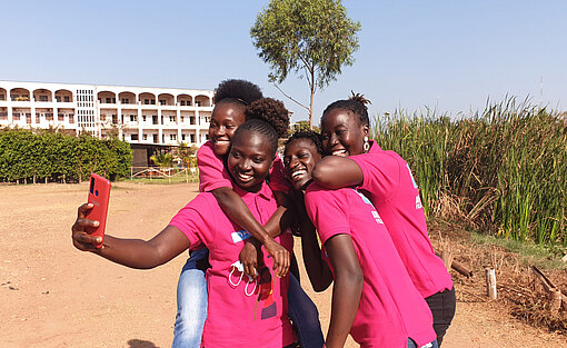 Auch in Guinea bietet die Girls Out Loud Initiative Mädchen und jungen Frauen Rückhalt und Solidarität. Vier Mädchen in pinken Tshirts machen ein Selfie.