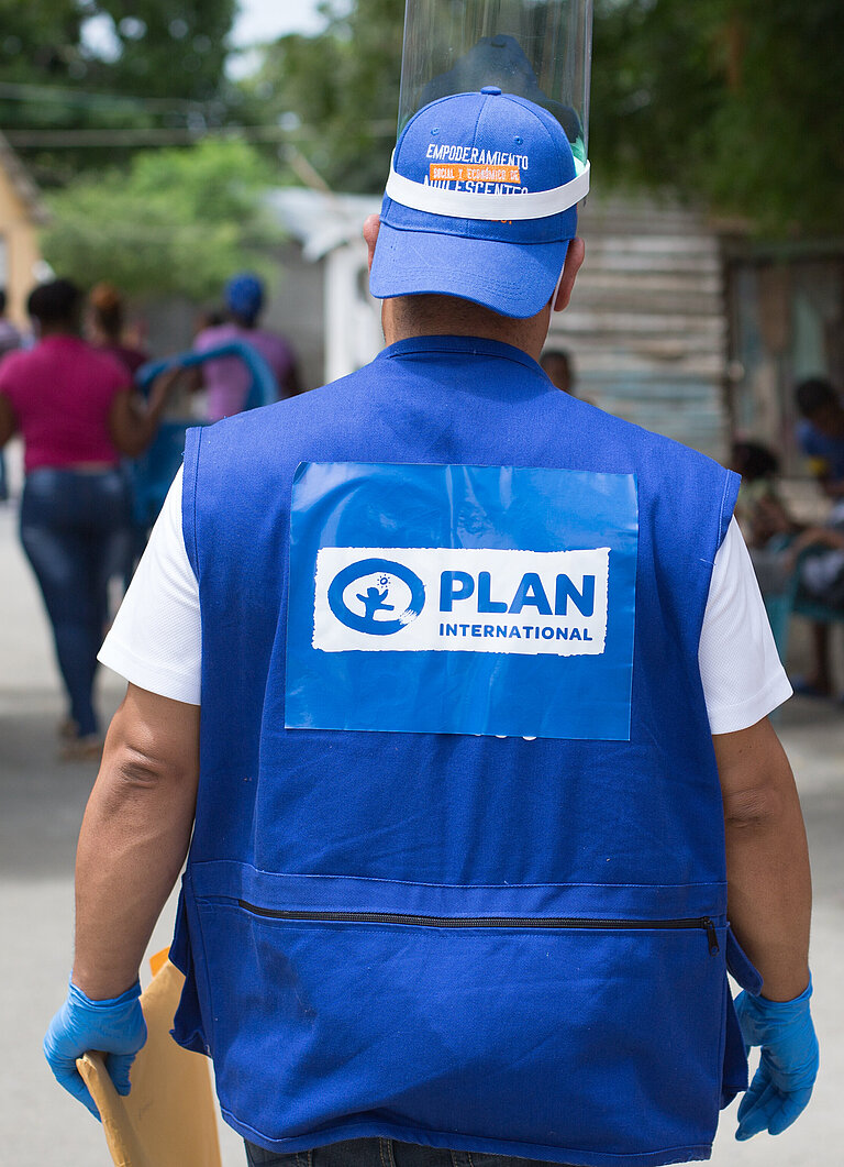 Mitarbeiter von Plan geht auf Menschen zu.