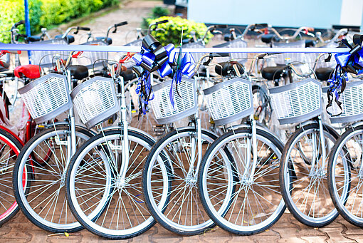 Neue Fahrräder mit Schleifen an den Lenkern stehen in einer Reihe nebeneinander