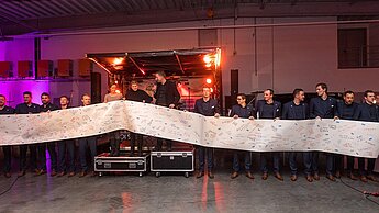 Plan-Mitarbeiterinnen überreichten dem Team ein 11-Meter langes Banner auf dem Fans Saison-Wünsche verewigt hatten. Plan-Mitarbeiterinnen überreichten dem Team ein 11-Meter langes Banner auf dem Fans Saison-Wünsche verewigt hatten.