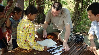 Ralf Spachmann zeigt Malaen Fotos aus seiner Heimat.