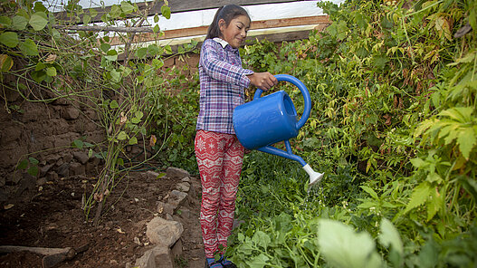 Mädchen gießt Pflanzen