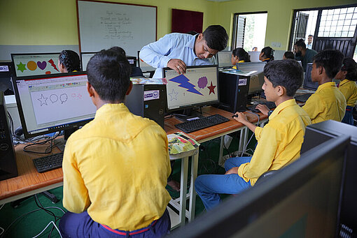 Lehrer erklärt Schüler:innen das Programm Microsoft Paint