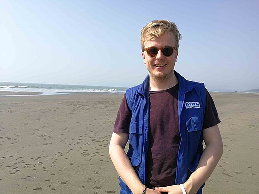 Björn Klüver an einem breiten Sandstrand.