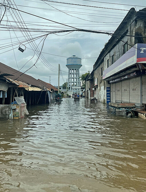 Eine Straße mit Läden und Häusern steht komplett unter Wasser