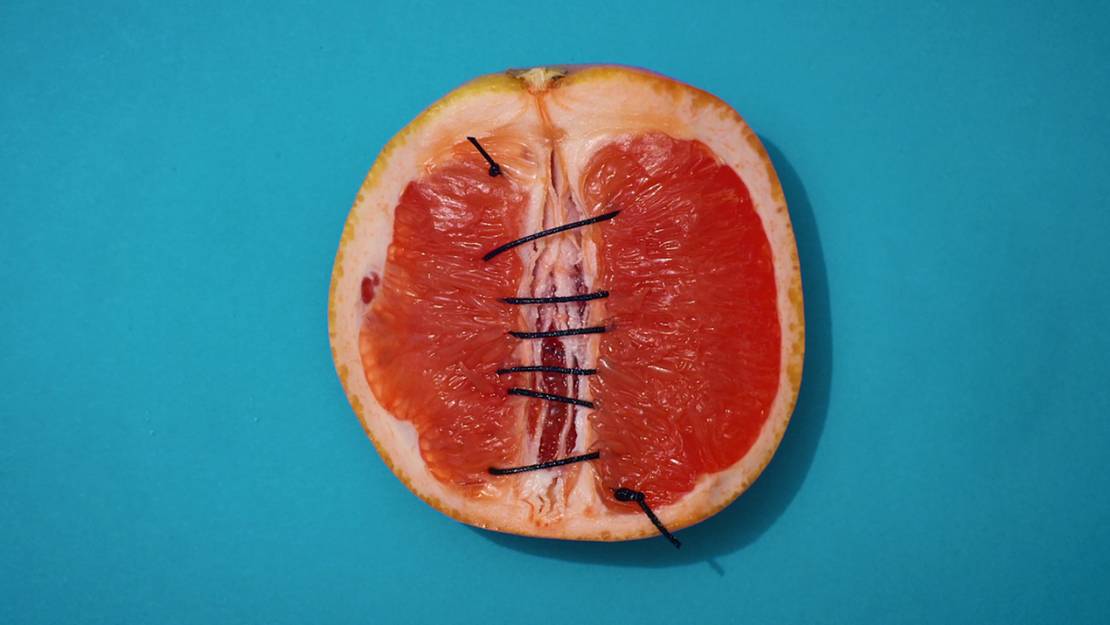 Zusammengenähte Grapefruit vor blauem Hintergrund.