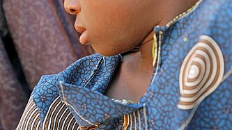 Ein kleiner Junge sitzt auf einer Matte