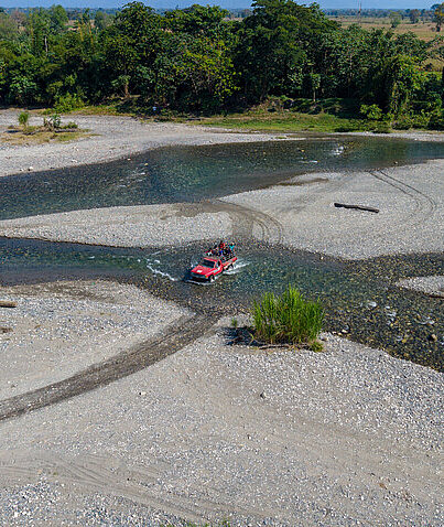 Ein Auto überquert den Fluss der Gemeinde in Alta Verapaz