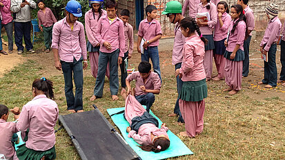 Schulkinder zeigen gelernte Erste-Hilfe-Übungen