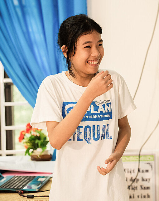 Ein junges vietnamesisches Mädchen lacht.