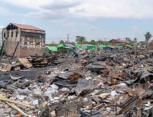 Blick auf eine freie Fläche voller Schutt, Holzresten, Mauern und Hausrat