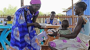 Die freiwillige Plan-Gemeindehelferin Ngachower Etcho (56) verteilt Zusatznahrung. © Plan International Die freiwillige Plan-Gemeindehelferin Ngachower Etcho (56) verteilt Zusatznahrung. © Plan International